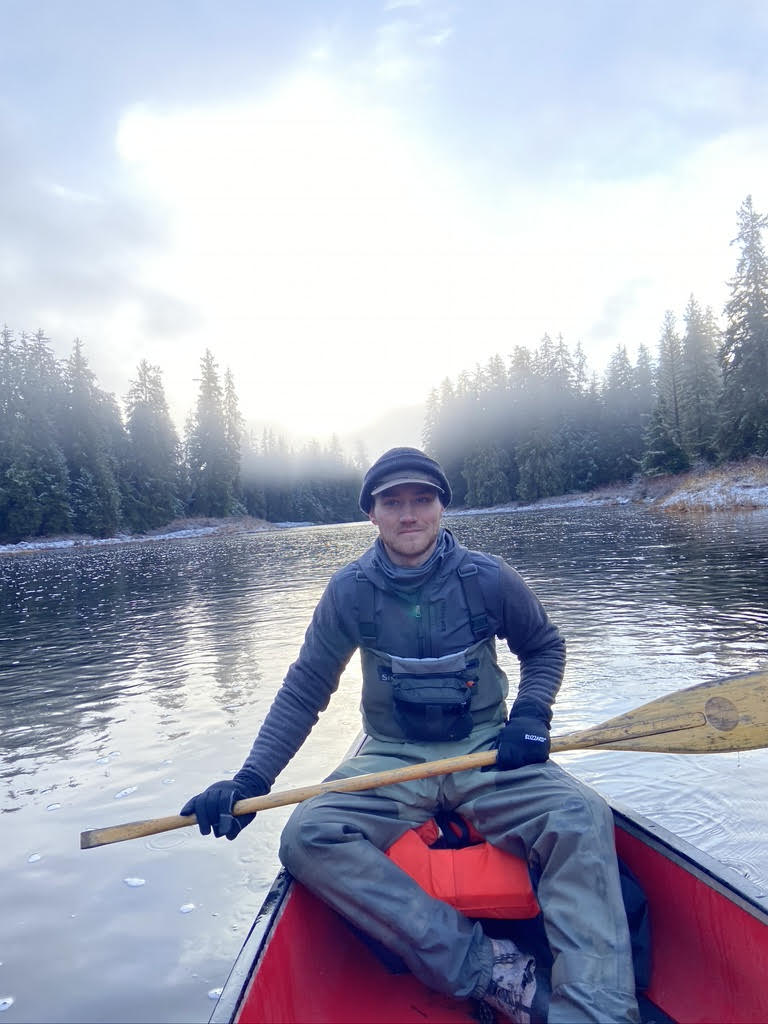 tutor Ian Jensen sits in a canoe on the water